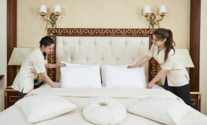 2 female housekeepers preparing the bed in a hotel