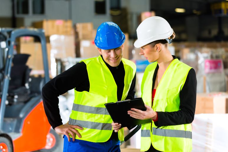 female safety supervisor discussing safety points to a forklift operator